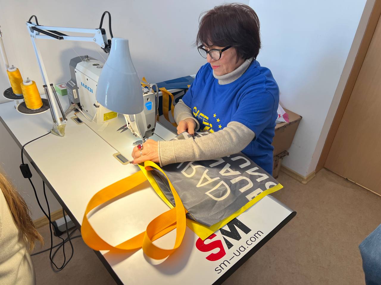 Родини полеглих військових шили шопери, які продаватиме відомий дизайнер у Берліні